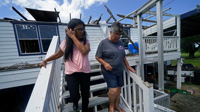 Louise Billiot, left, a member of the United Houma Nation Indian tribe, walks around the home...