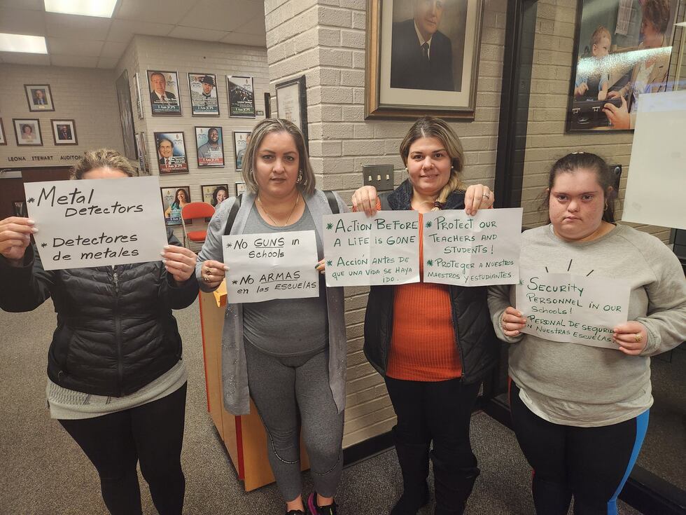 Parents held up signs at the JCPS school board meeting Thursday night.
