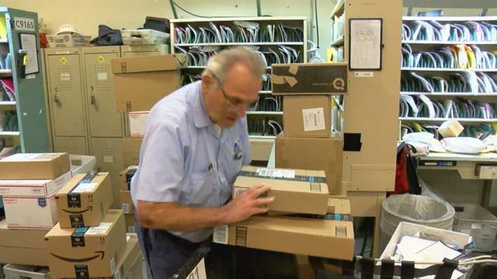 After the ceremony honoring him, John Osborne sorted packaged for delivery on his route....