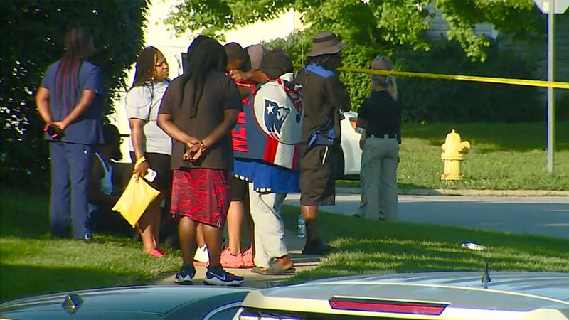 People are seen near the scene of a shooting where a 16-year-old was killed on Thursday in...