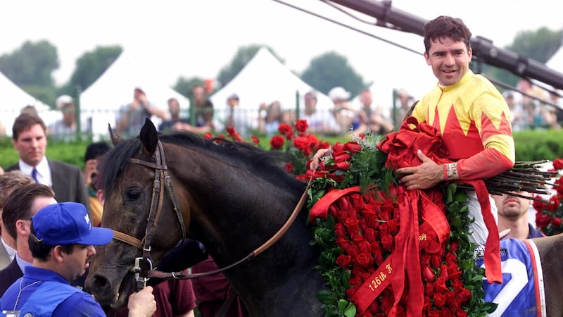 The blanket of roses lays draped across the back of winning horse Fusaichi Pegasus with jockey...