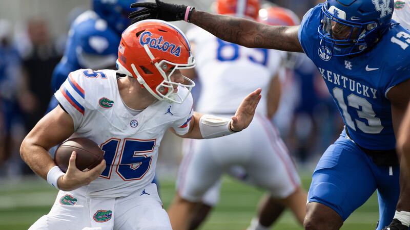 Florida quarterback Graham Mertz (15) pressured by Kentucky linebacker J.J. Weaver (13) during...