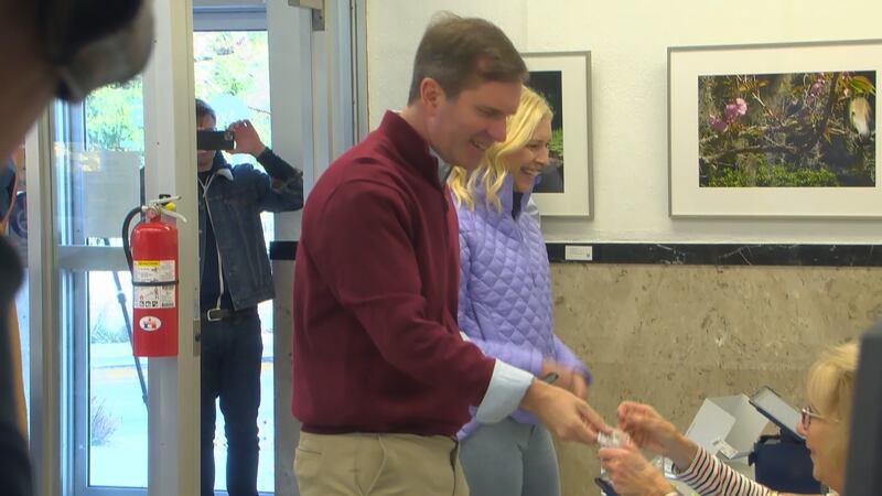 Governor Andy Beshear presents a photo ID to early vote at a Frankfort polling place Thursday...