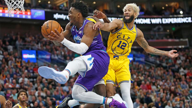 Utah Jazz guard Donovan Mitchell, left, goes to the basket as Golden State Warriors guard Ky...