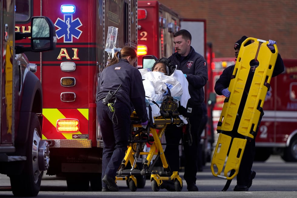 A patient, center, is placed into an ambulance while being evacuated from Signature Healthcare...